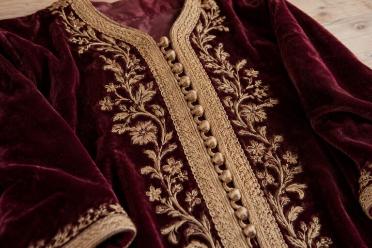 Gros plan d'une sfifa dorée et d'aqads sur un caftan en velours bordeaux